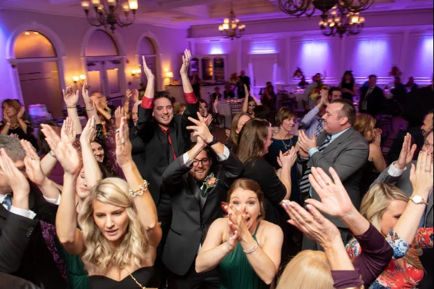 Guests cheering on a packed dance floor