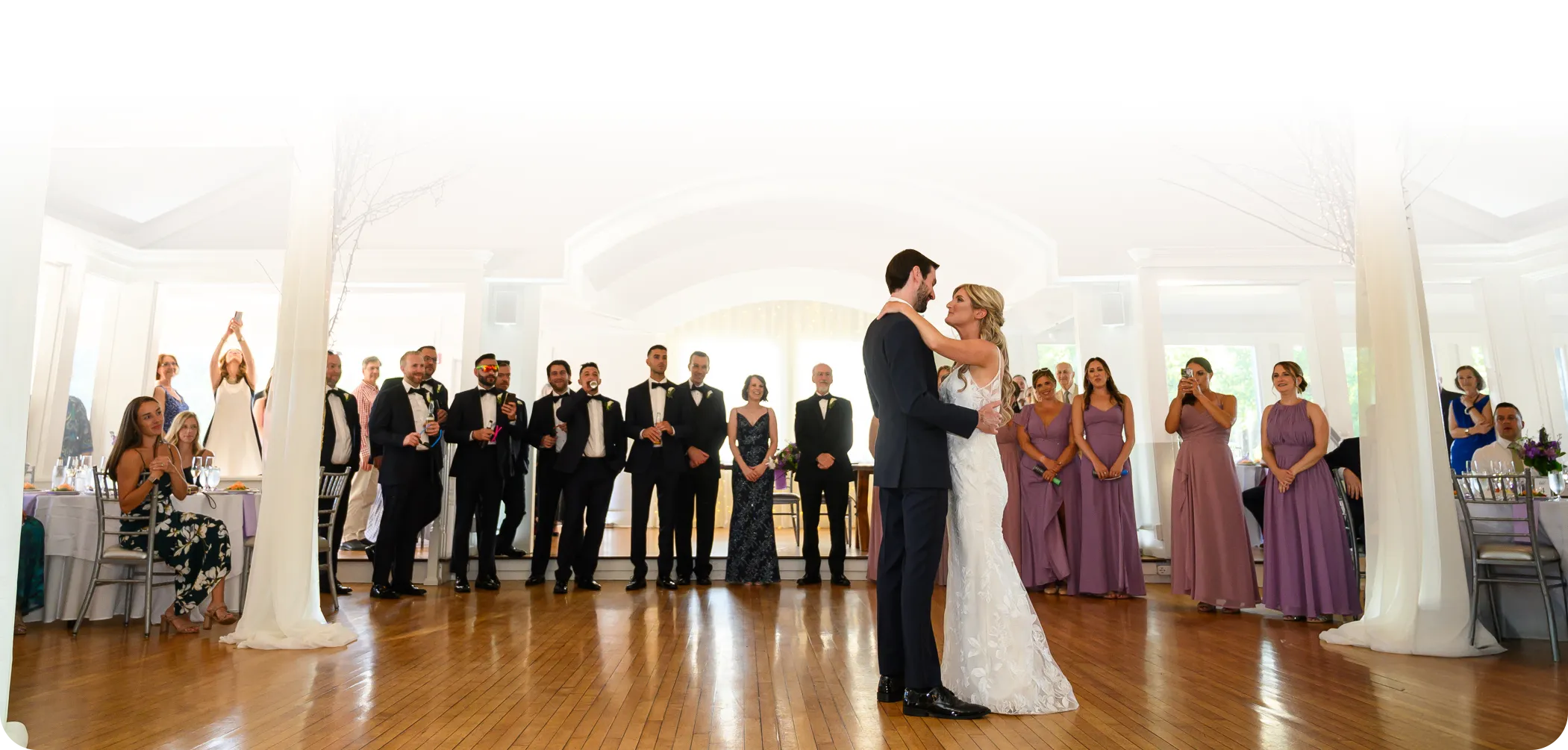 A couple's first dance in front of their wedding party